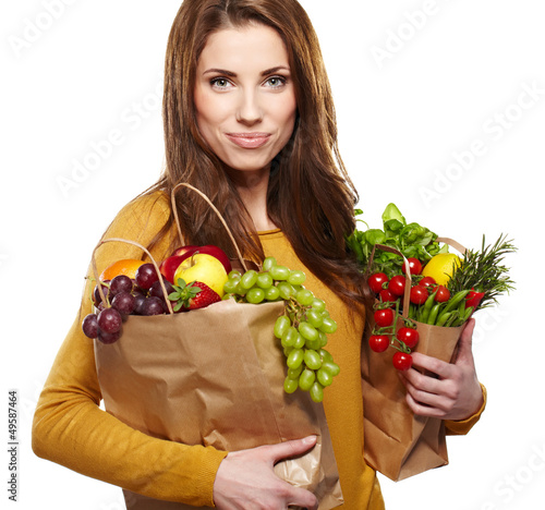 Photo: Portrait of happy young female holding a shopping bag full of gr Portrait of happy young female holding a shopping bag full of gr