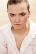 Scowling pretty girl posing in white shirt