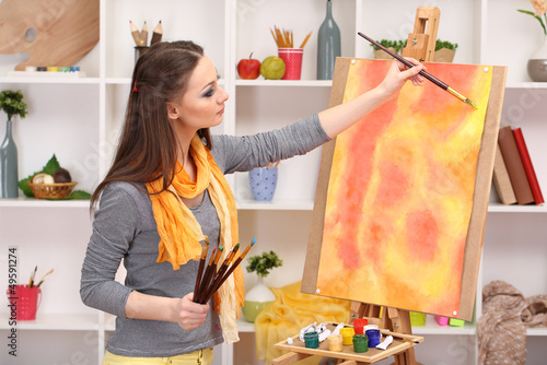Photo: beautiful young woman painter at work, beautiful young woman painter at work,