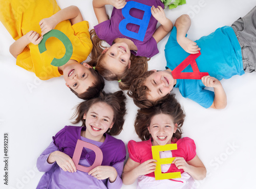 Photo: Happy school kids with colorful alphabet letters Happy school kids with colorful alphabet letters