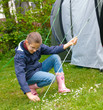 Camping in tent - happy girl on camp tent