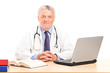 A mature doctor in his office posing