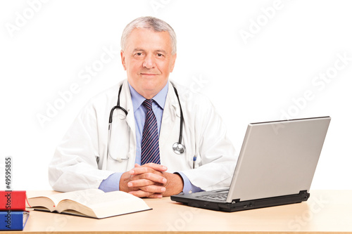 Photo: A mature doctor in his office posing A mature doctor in his office posing