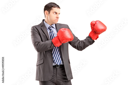 Photo: Angry man in suit with red boxing gloves ready to fight Angry man in suit with red boxing gloves ready to fight