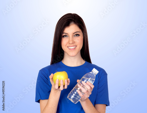 Photo: Teenager girl with a yellow apple and water Teenager girl with a yellow apple and water