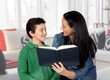Mother teaching her child to read .