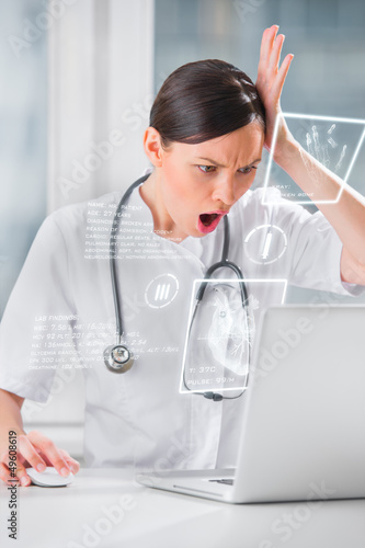Photo: Medical doctor working with hologram interface at hospital Medical doctor working with hologram interface at hospital