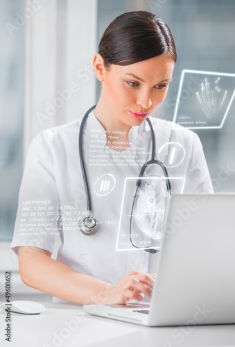 Photo: Pretty female medicine doctor working with modern computer inter Pretty female medicine doctor working with modern computer inter