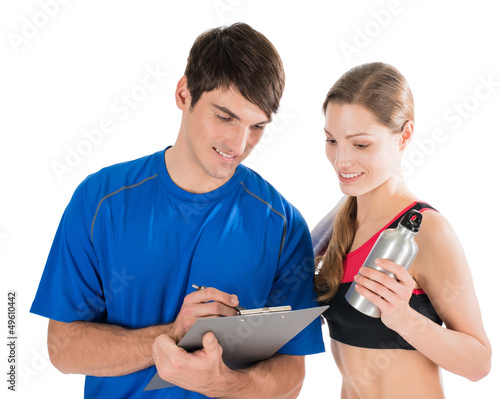 Photo: Personal trainer and customer evaluating workout results Personal trainer and customer evaluating workout results