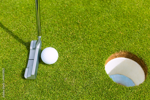 Photo: Golf player putting ball in hole Golf player putting ball in hole