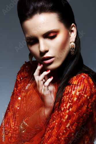 Photo: Portrait of Classy Bright Brunette in Red Shiny Dress. Luxury Portrait of Classy Bright Brunette in Red Shiny Dress. Luxury