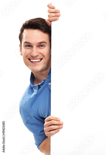 Photo: Man peeping over blank poster Man peeping over blank poster