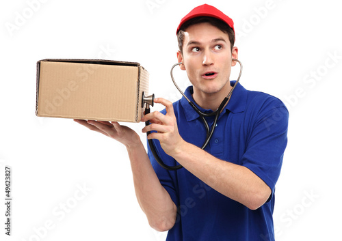 Photo: Delivery man examining box with stethoscope Delivery man examining box with stethoscope
