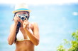 Summer beach woman holding camera taking picture