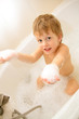 Boy in a bath with foam in hands