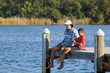 Father and son, about 8 years old, fishing off a wooden pier.