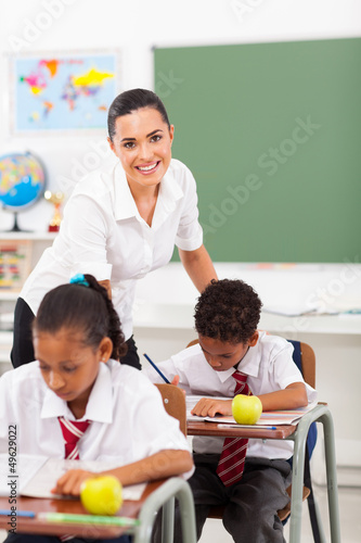 Photo: beautiful elementary school teacher in classroom with students beautiful elementary school teacher in classroom with students