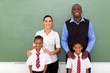 elementary school teachers and students in front of chalkboard