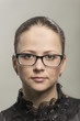 Portrait of the serious young woman in glasses