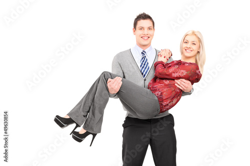 Photo: Happy young man carrying his girlfriend in his arms Happy young man carrying his girlfriend in his arms