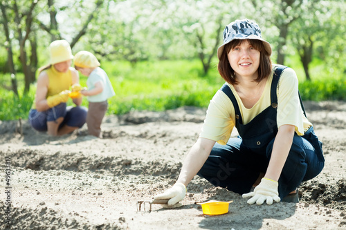 Photo: women with child works at garden women with child works at garden