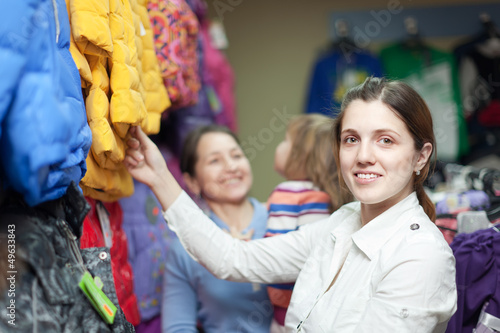 Photo: family chooses jacket at clothes store family chooses jacket at clothes store
