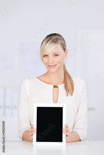 Photo: lächelnde blonde frau zeigt tablet-monitor lächelnde blonde frau zeigt tablet-monitor