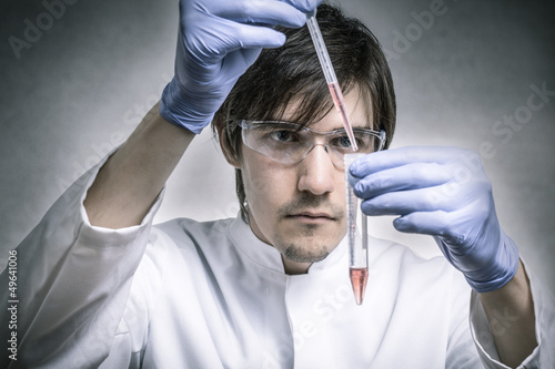 Photo: Forscher verwendet Pipette mit roter Flüssigkeit Forscher verwendet Pipette mit roter Flüssigkeit
