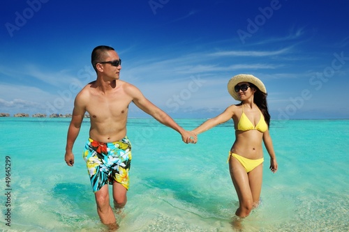 Photo: happy young couple enjoying summer on beach happy young couple enjoying summer on beach