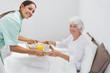 Home nurse giving a breakfast to the old woman