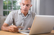 Thoughtful mature man using his laptop