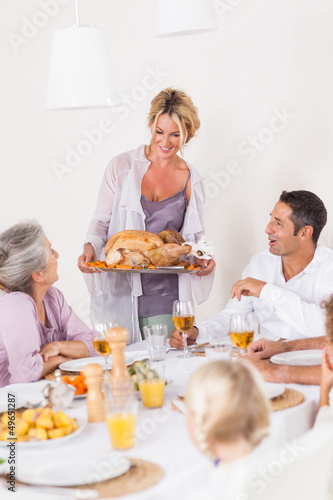 Photo: Mother bringing turkey to dinner table Mother bringing turkey to dinner table