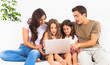 Family posing on a sofa with the laptop