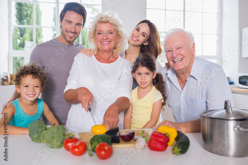 Photo: Multi-generation family cutting vegetables together Multi-generation family cutting vegetables together