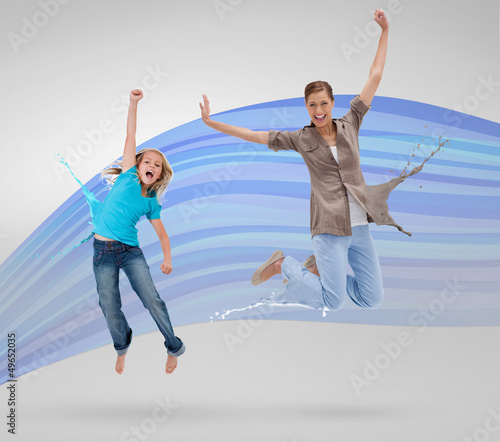 Photo: Woman and daughter jumping with clothes turning to paint splatte Woman and daughter jumping with clothes turning to paint splatte
