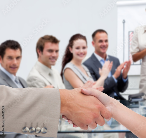 Photo: Businessman and woman shaking hands in presentation Businessman and woman shaking hands in presentation
