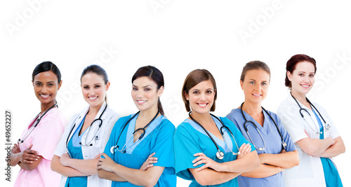 Photo: Smiling female hospital workers standing arms folded in line Smiling female hospital workers standing arms folded in line