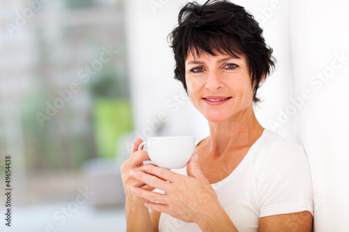 Photo: attractive mid age woman enjoying coffee at home attractive mid age woman enjoying coffee at home