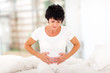 Photo: mid age woman having stomach pain at home mid age woman having stomach pain at home