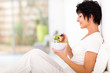 Photo: elegant middle aged woman sitting on bed and eating salad elegant middle aged woman sitting on bed and eating salad