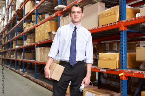 Photo: Businessman With Package And Scanner In Warehouse Businessman With Package And Scanner In Warehouse