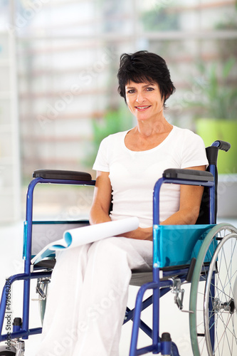 Photo: handicapped middle aged woman reading book on wheelchair handicapped middle aged woman reading book on wheelchair