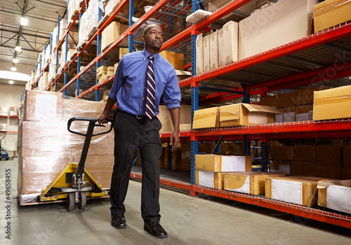 Photo: Man Pulling Pallet In Warehouse Man Pulling Pallet In Warehouse