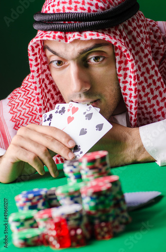 Photo: Arab playing in casino - gambling concept with man Arab playing in casino - gambling concept with man