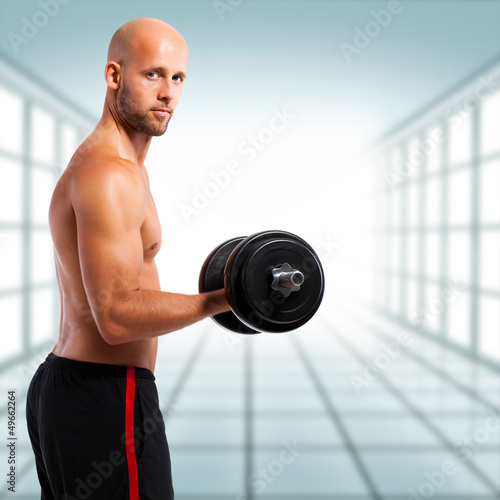 Photo: muskulöser Sportler beim Kurzhanteltraining muskulöser Sportler beim Kurzhanteltraining