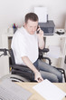 young man in wheelchair at work, having a phone call