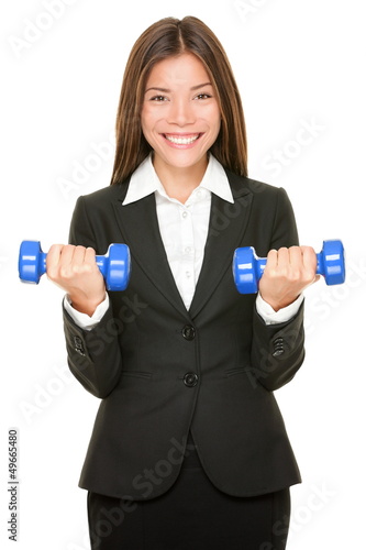 Photo: Business woman in suit lifting dumbbell weights Business woman in suit lifting dumbbell weights