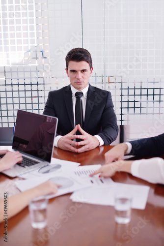 Photo: business man on a meeting in offce with colleagues in backgroun business man on a meeting in offce with colleagues in backgroun