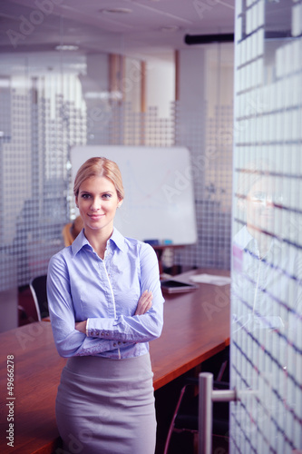 Photo: business woman with her staff in background at office business woman with her staff in background at office
