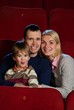 Young man and woman with their child in a cinema
